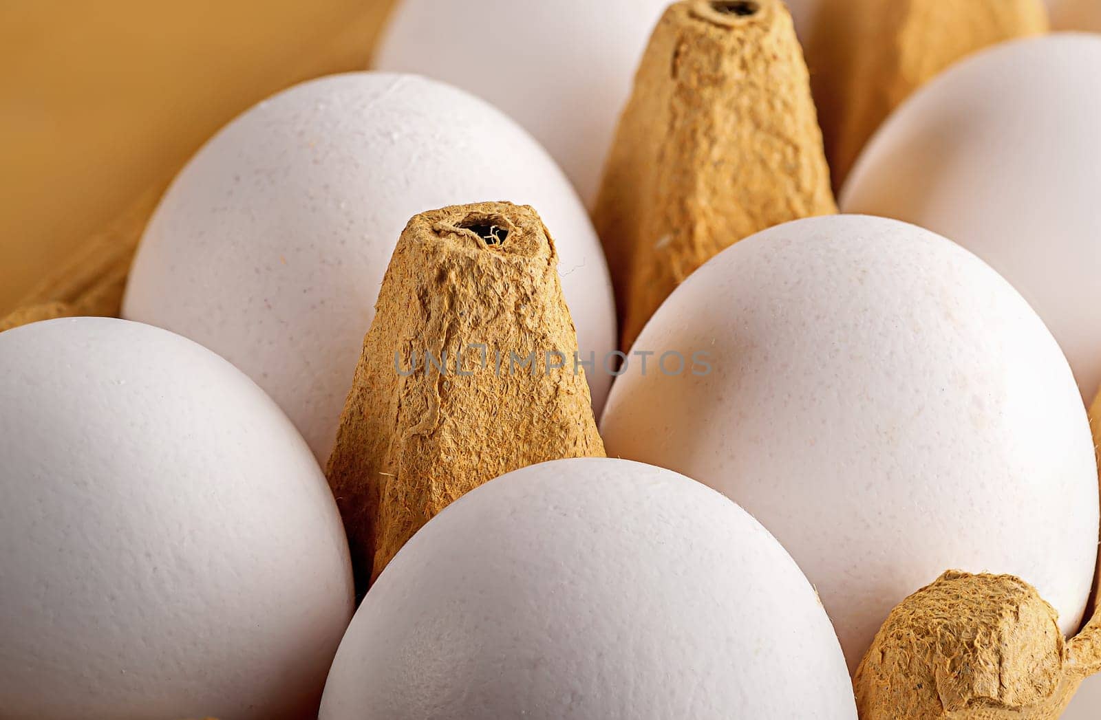 White eggs in yellow paper tray closeup
