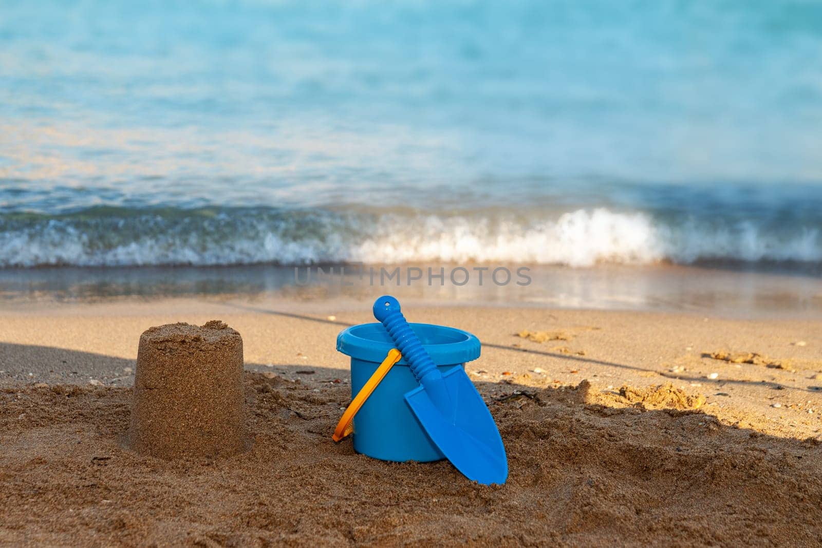 A person sitting on a sandy beach next to the oceanundefined