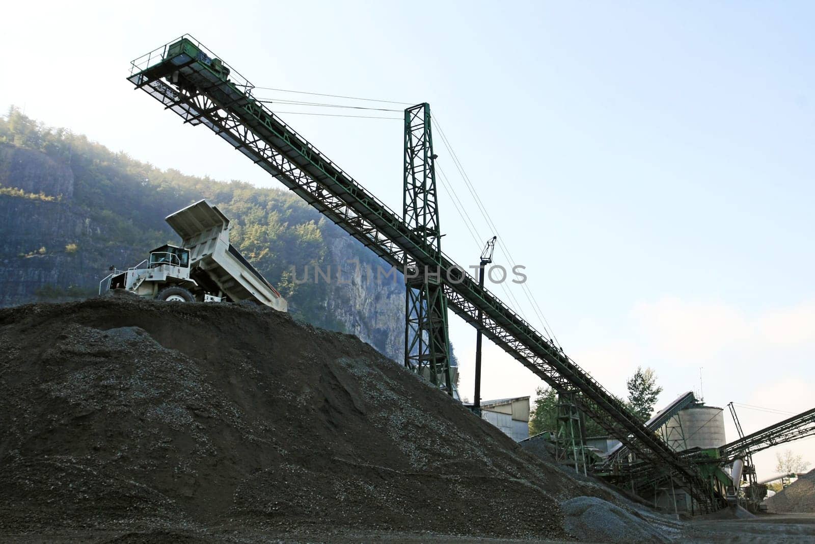 A gravel pit with tools and trucks in the mountains