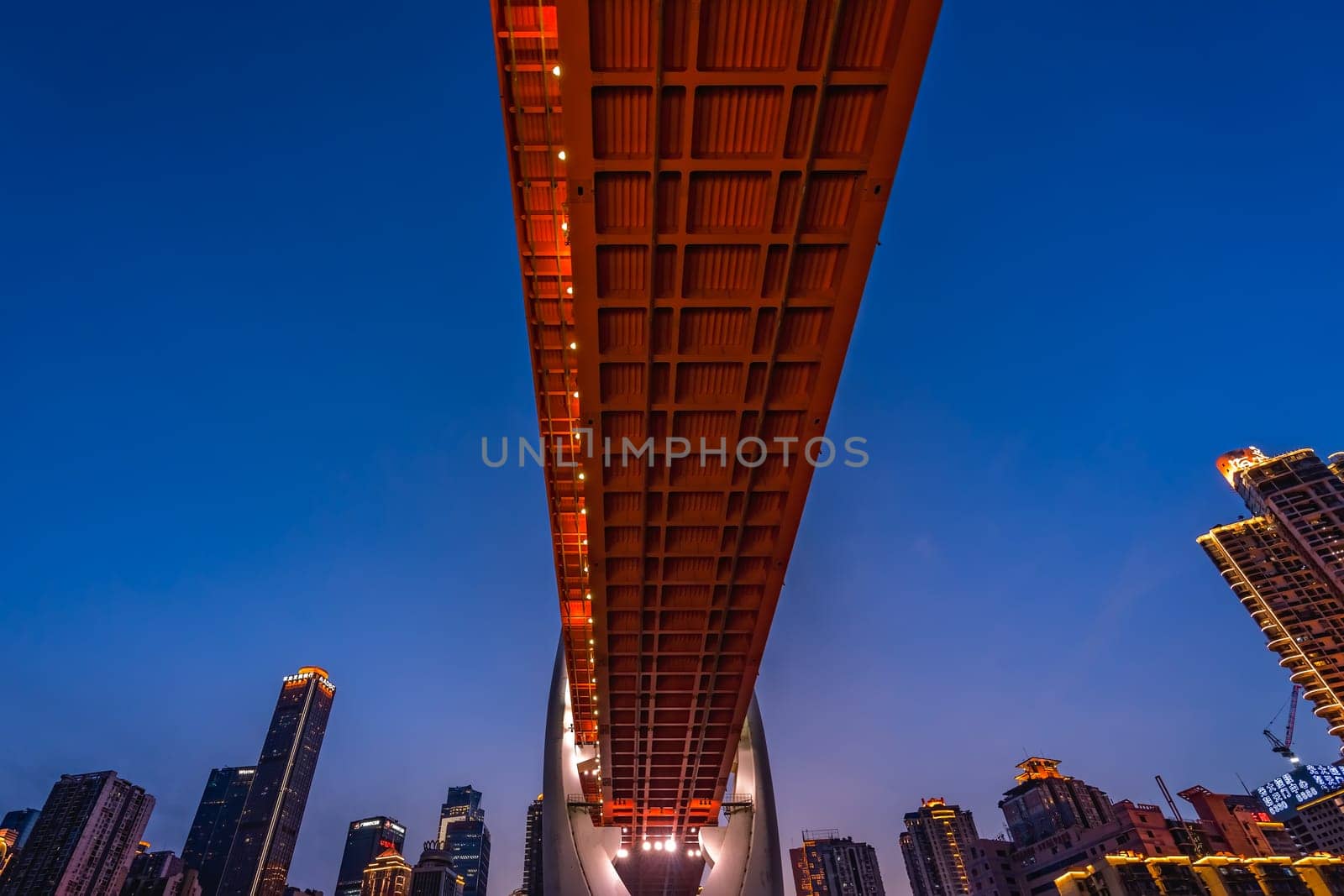 Chongqing, China -  August 2019 : Illuminated DongShuiMen road bridge over and across mighty Yangtze river in Chongqing town at dusk