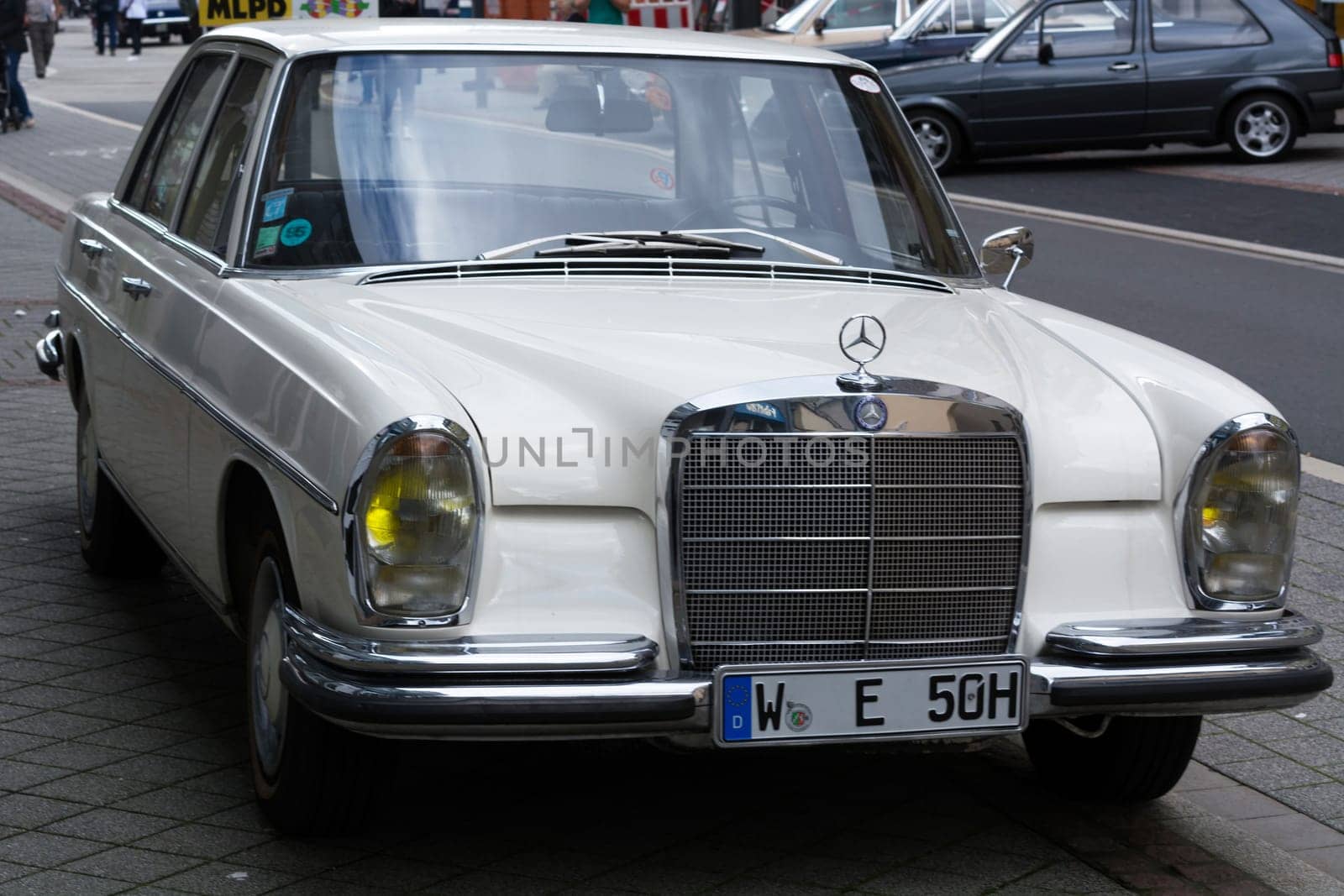 HEILIGENHAUS, NRW, GERMANY - SEPTEMBER 10, 2017:.Heiligenhaus, Nrw, Germany - September 10, 2017:.White classic car Mercedes Benz on a street. Mercedes-Benz is a German automaker. The brand produces luxury cars, buses, coaches and trucks.