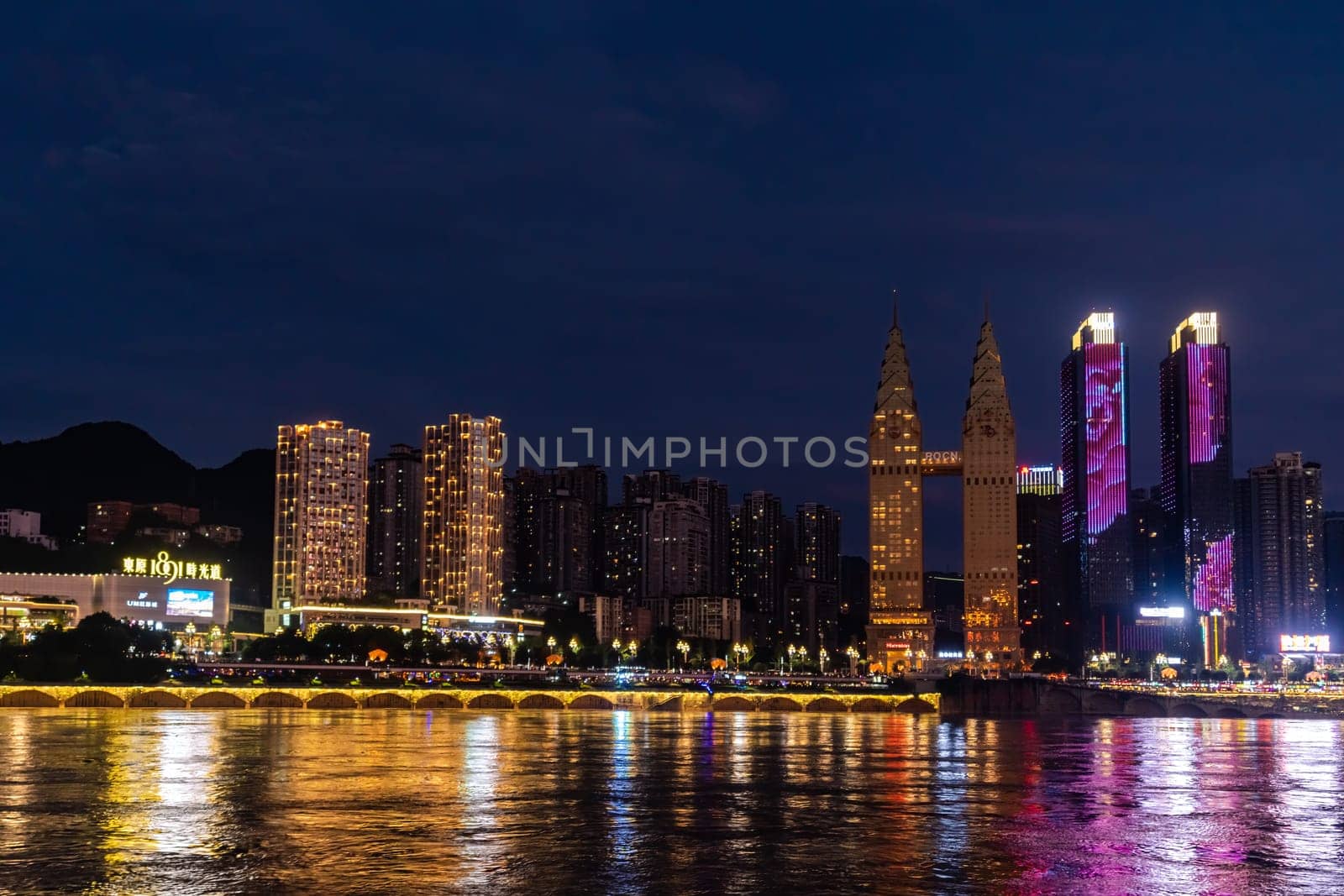 Chongqing, China -  August 2019 : Night view of the Chongqing city lights over Jialing and Yangtze river with illuminated skyscrapers in the background
