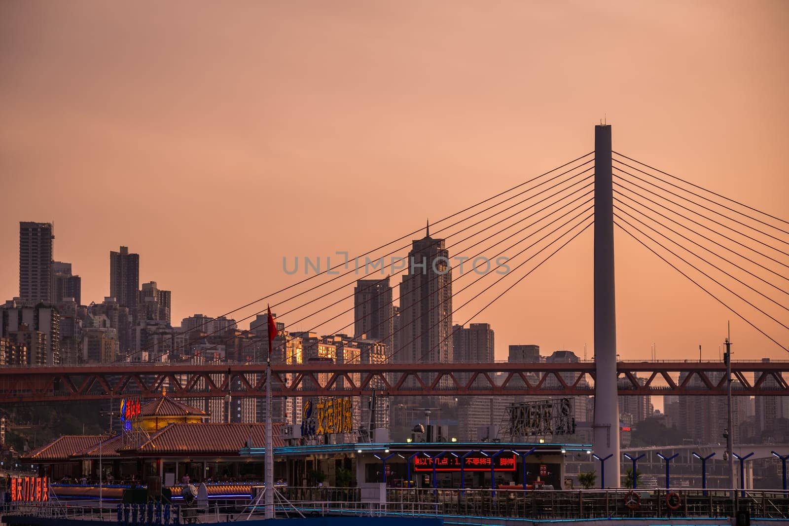 Chongqing, China -  August 2019 : Steel road bridge over Yangtze and Jialing rivers in Chongqing town at dusk