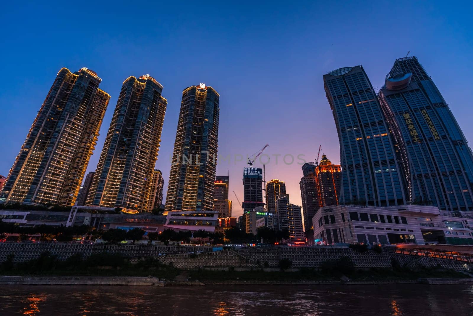 Chongqing, China -  August 2019 : Night view of the modern commercial and business buildings on the riverside at dusk
