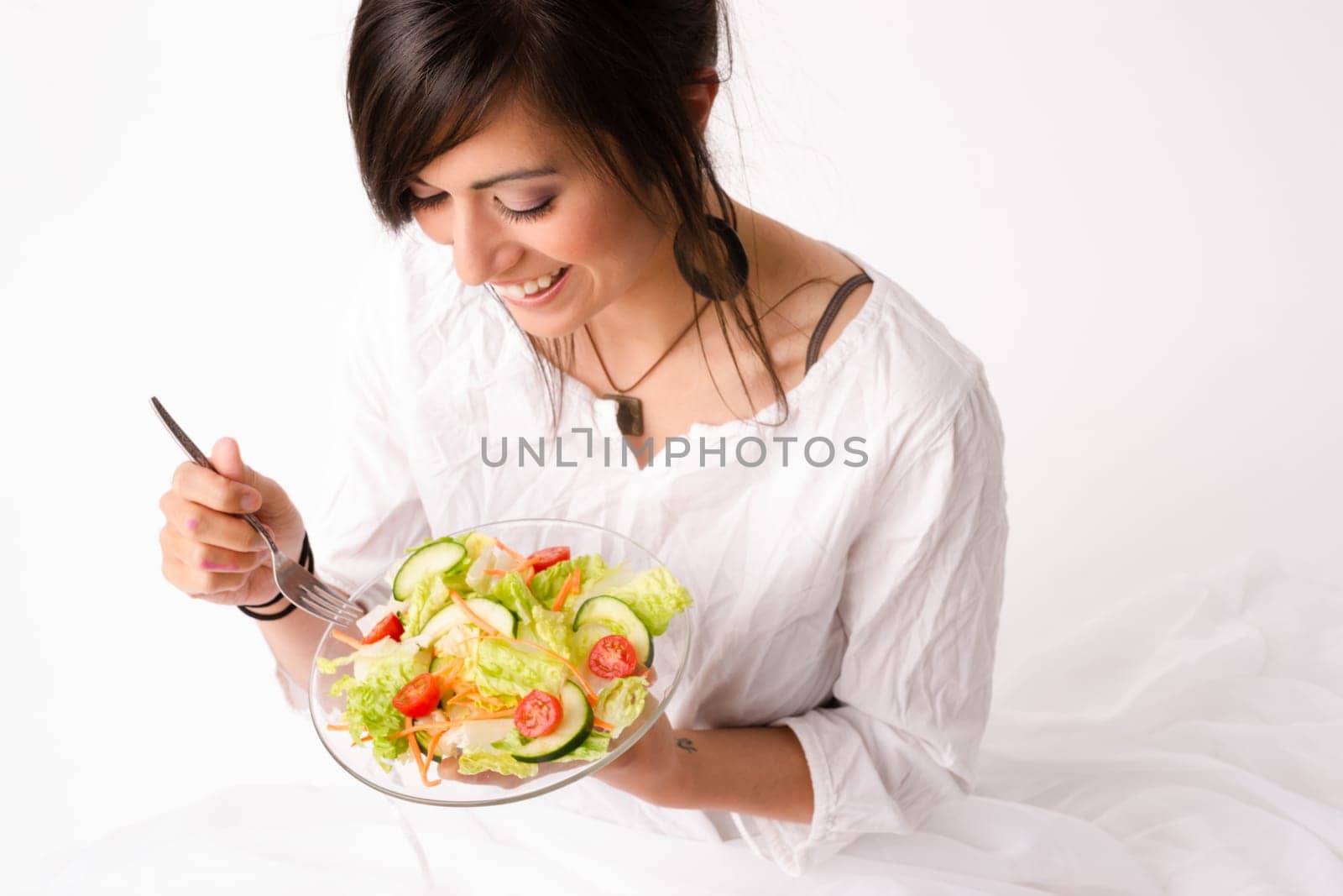 An attractive woman takes in the aroma of the salad she is about to consume