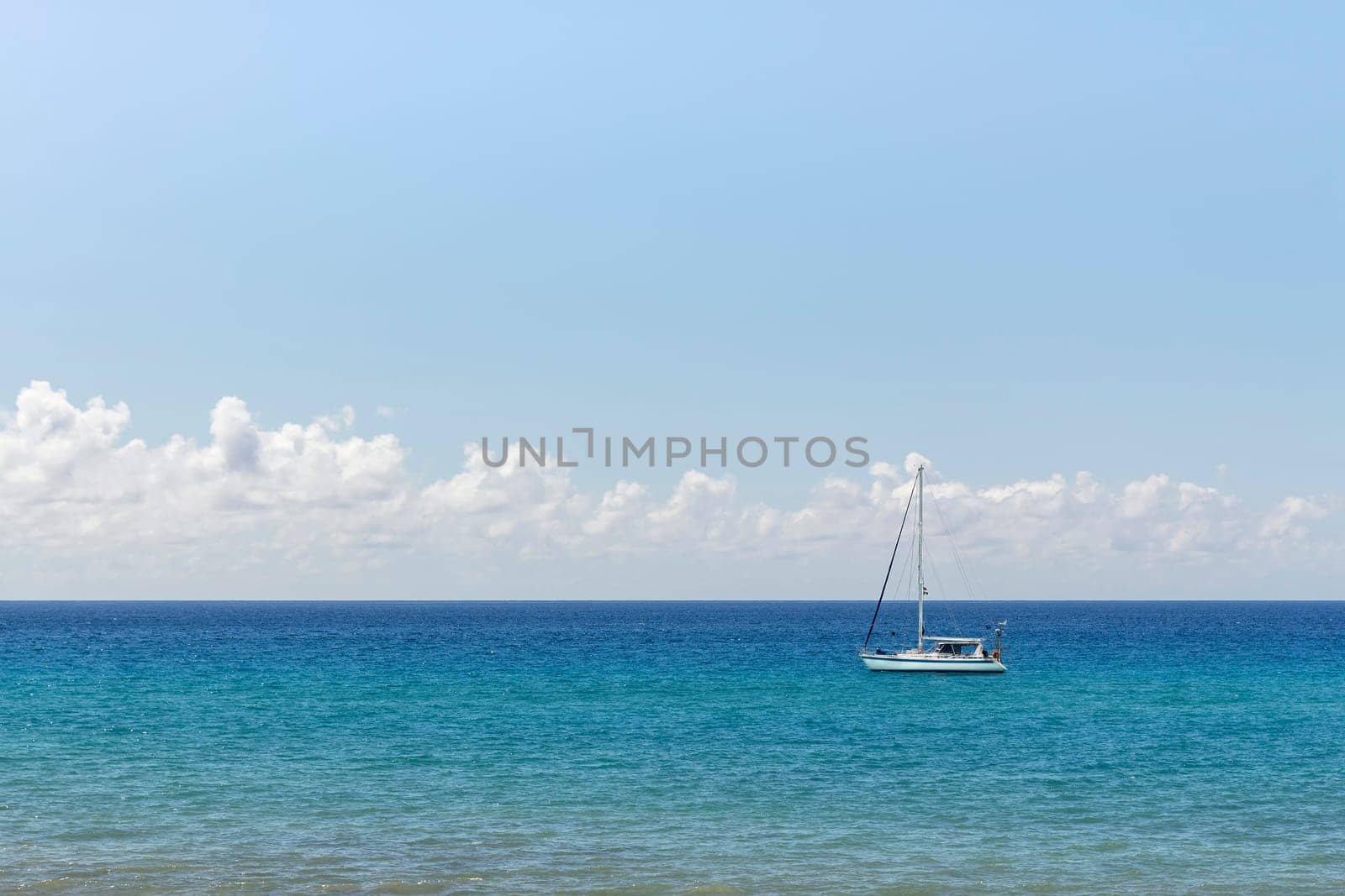 Minimalist seascape with a white boat on a turquoise waters and cloudy sky