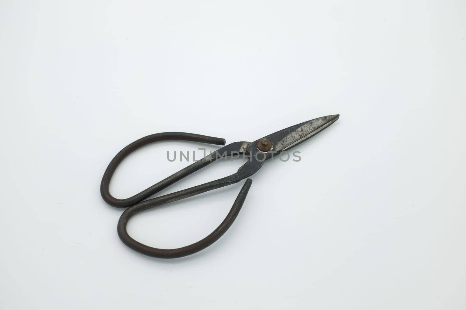 black vintage scissors on white textured background.
