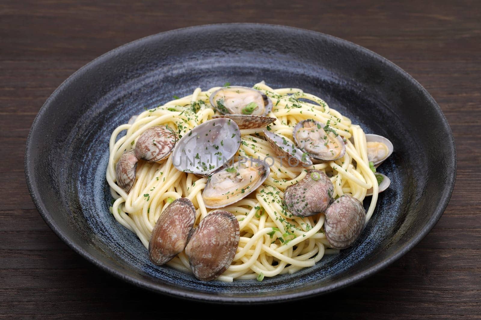 Vongole spaghetti in a dish on wooden table