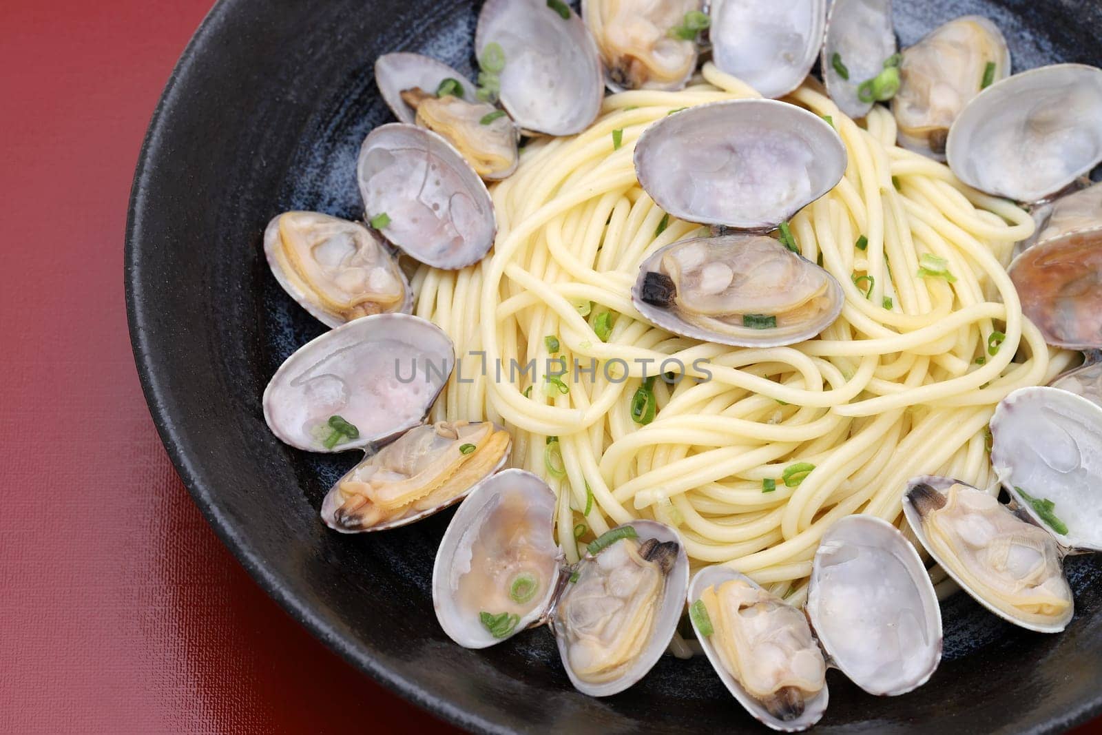 Close up of Vongole spaghetti in a dish on wooden table