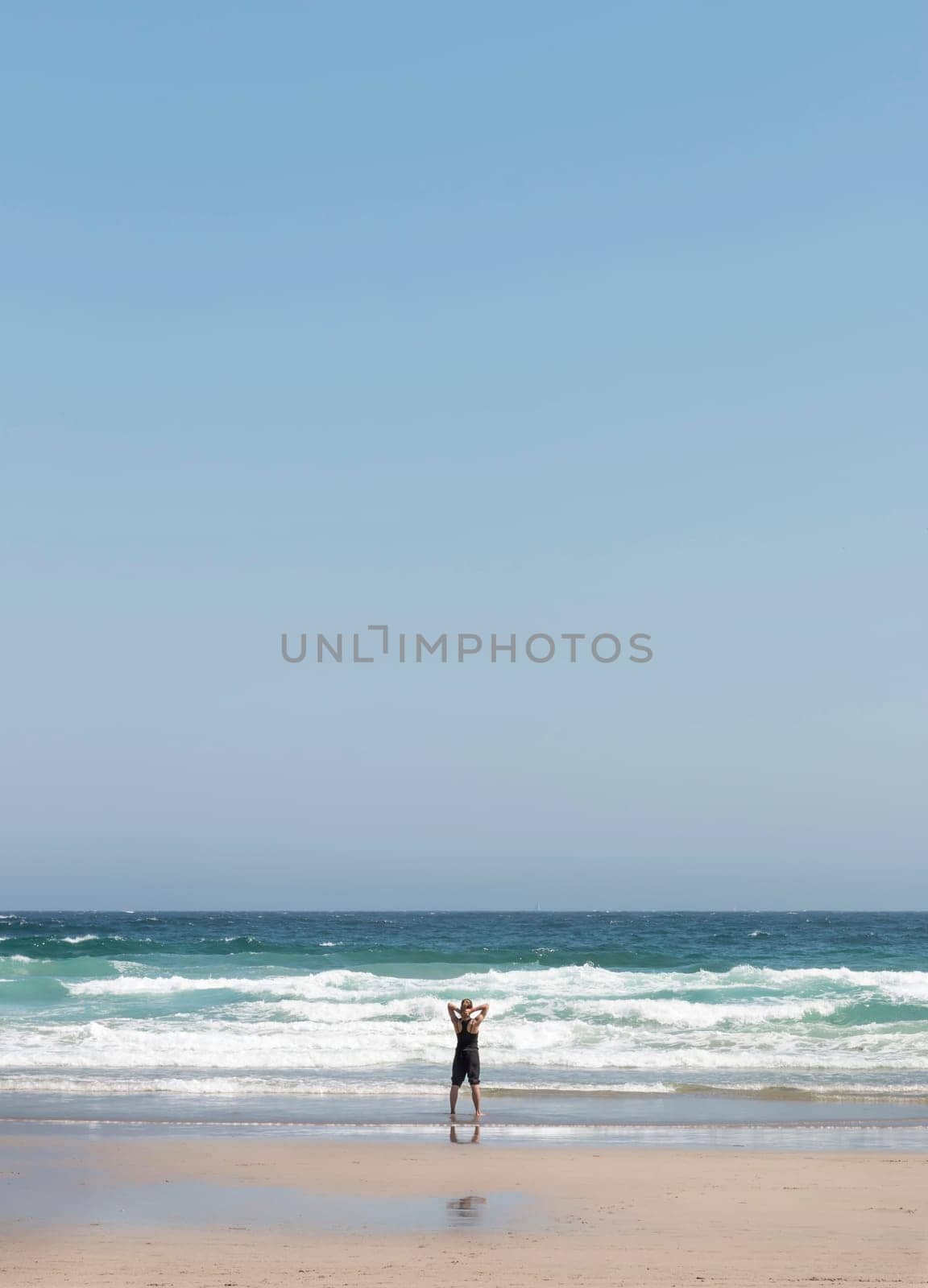 Relaxed blonde girl on her back contemplating the waves at the seashore