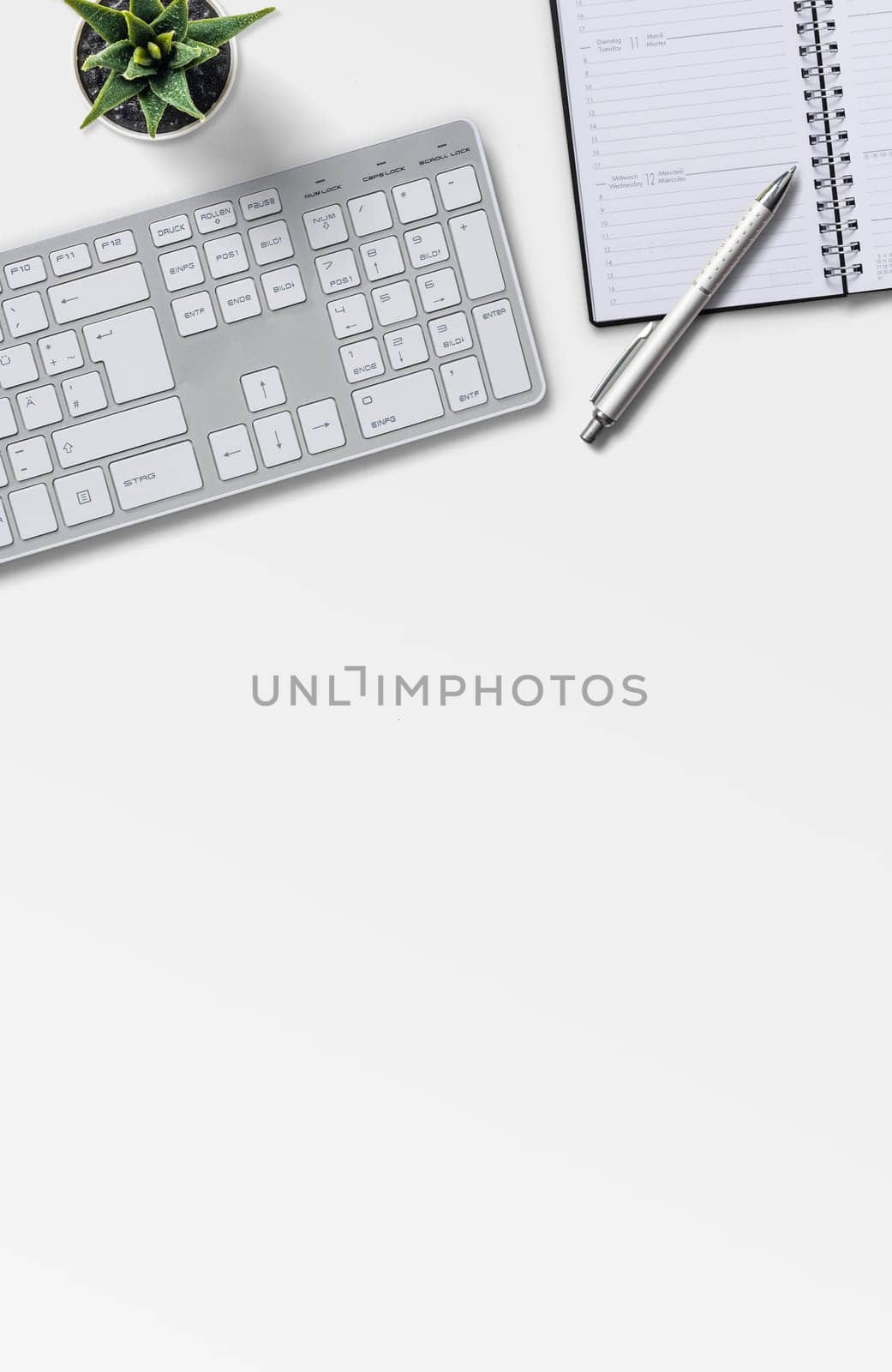 Top view of a workplace with office supplies on a white background