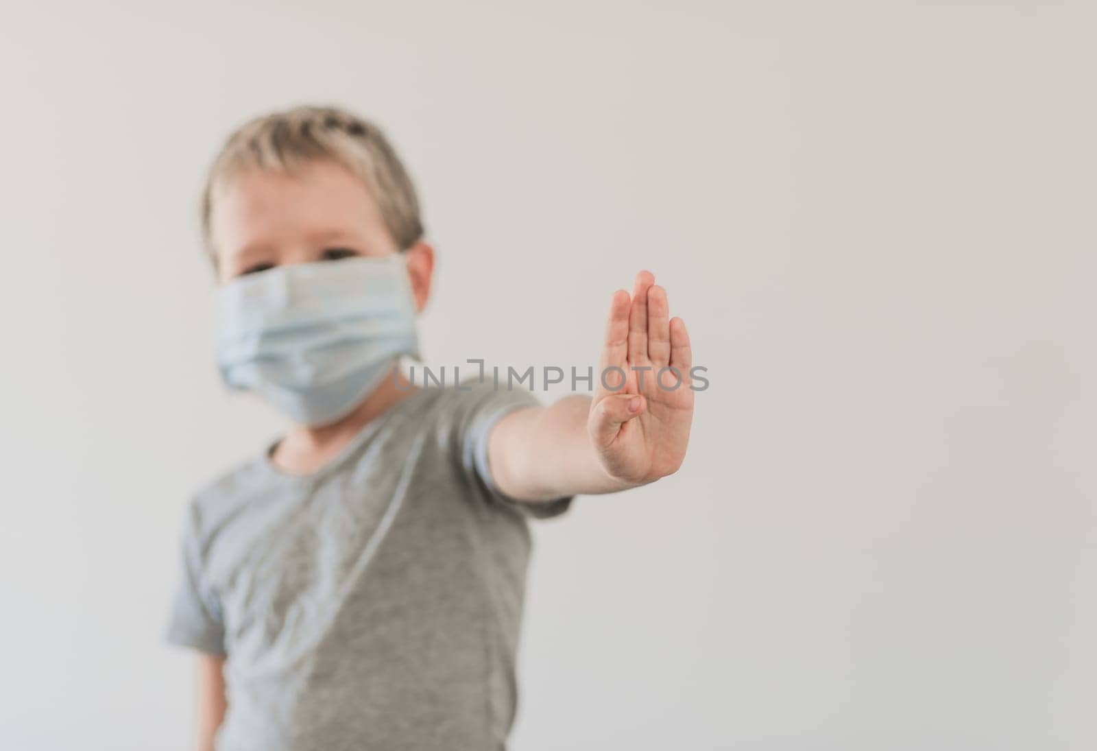 Boy wearing facial disposable mask to avoid viral infection. Stop coronavirus