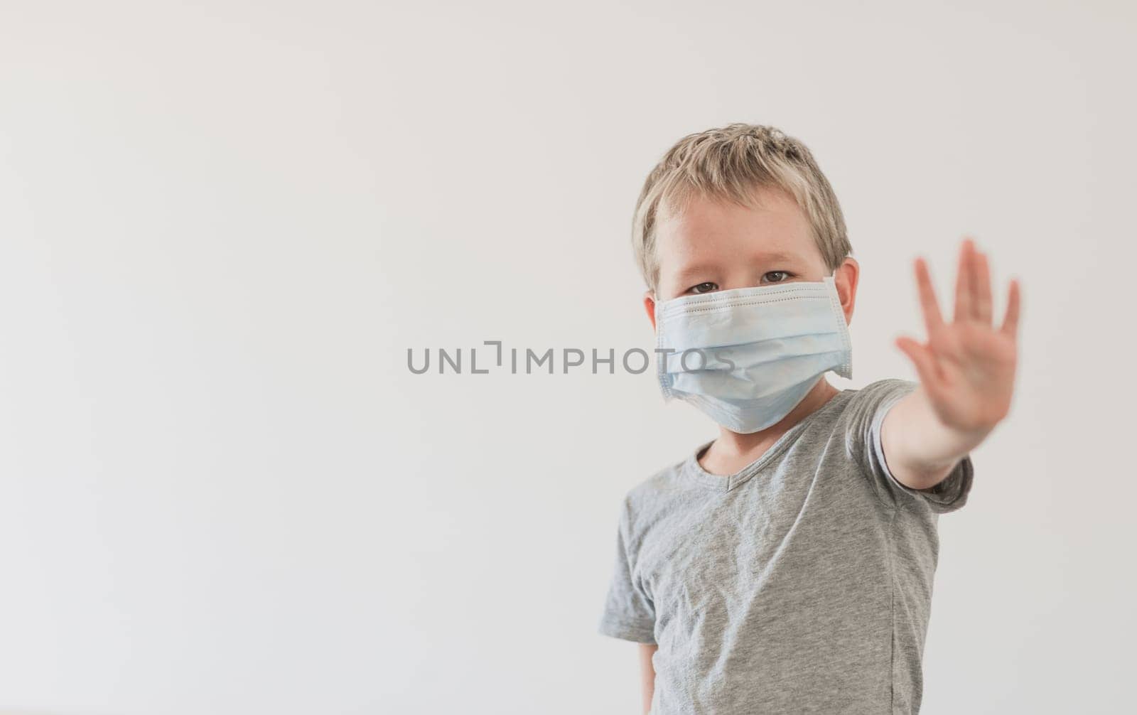 Boy wearing facial disposable mask to avoid viral infection. Stop coronavirus