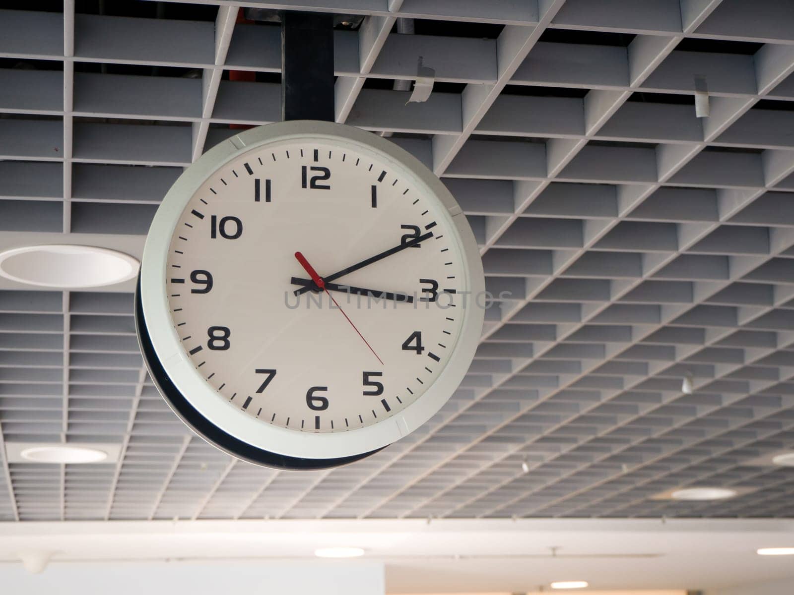 train station clock hanging from the ceiling.