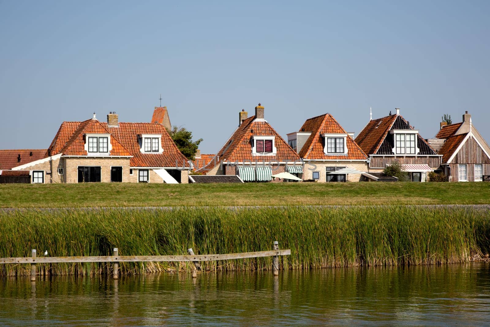 Historic houses behind te dike in Makkum, the Netherlands..