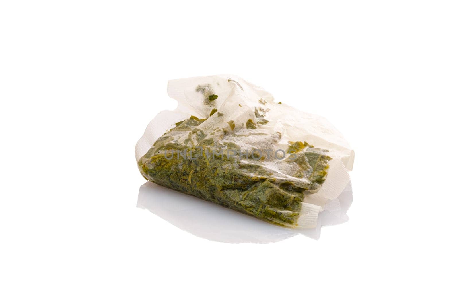 Wet green tea bag close-up white isolated