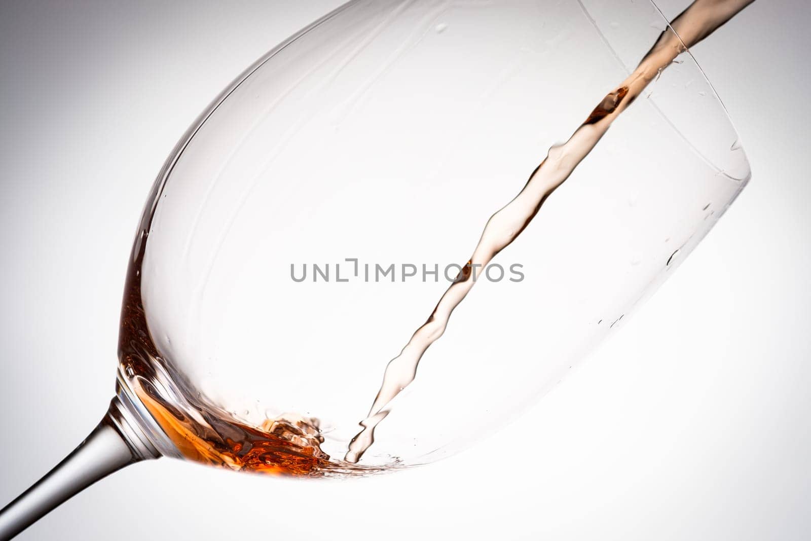 Pouring rose wine in a glass close-up