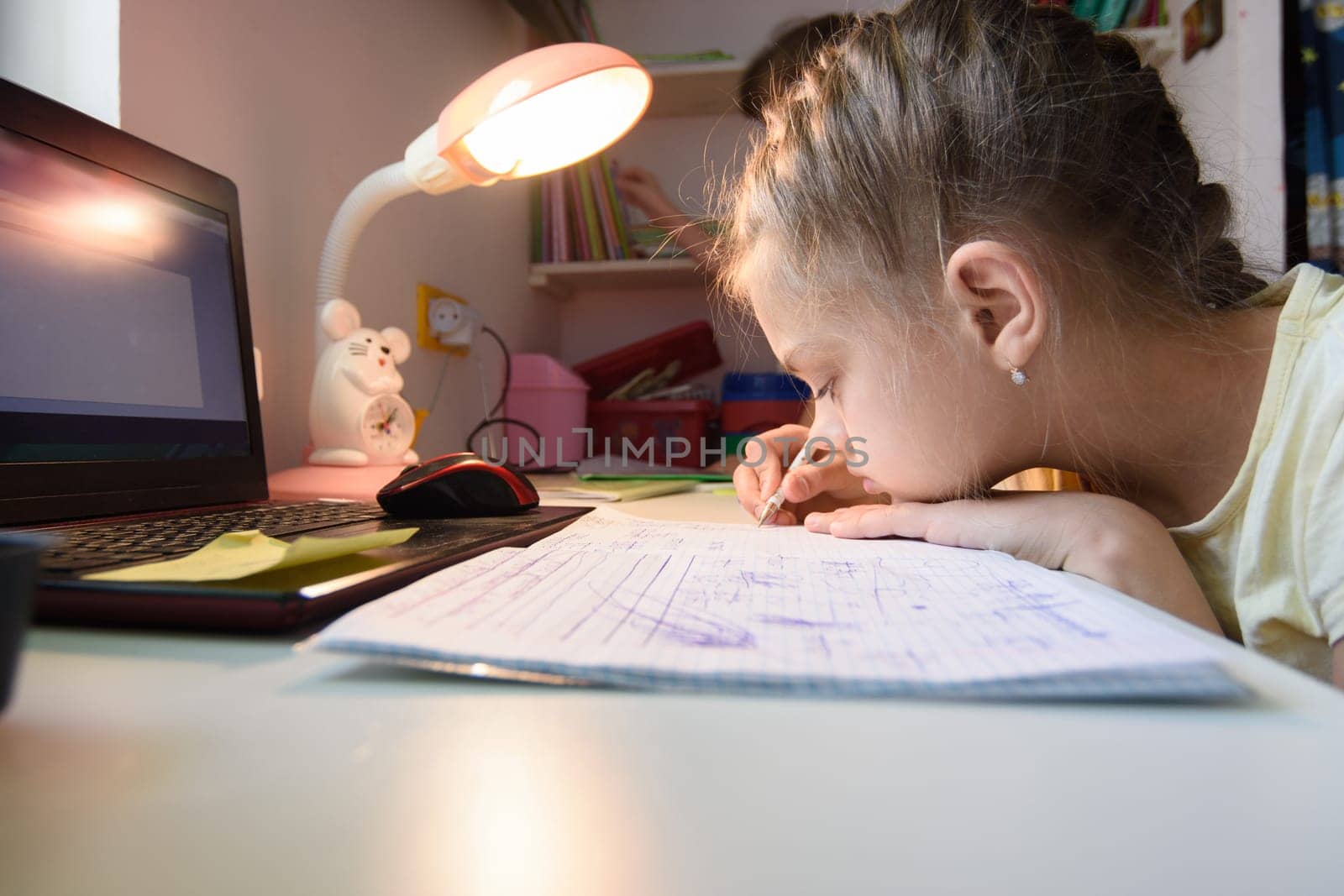 The girl is studying at home remotely while in her room