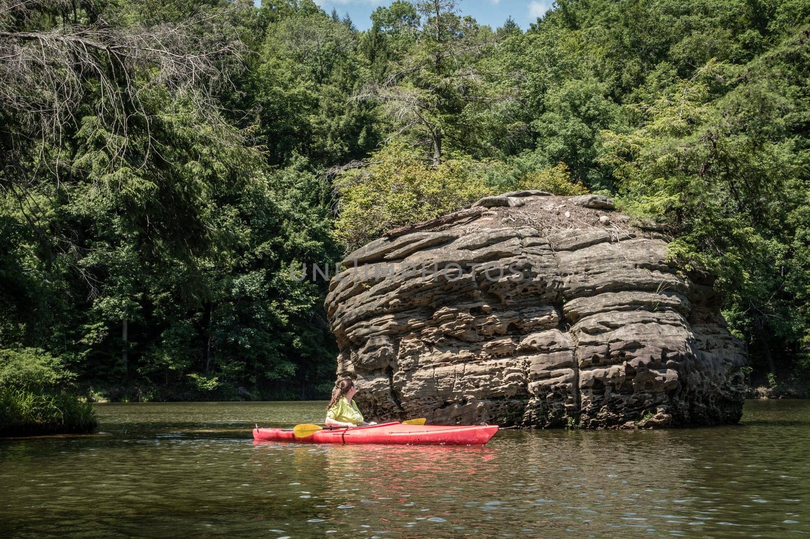 Kayaker looking at a rock formation on Grayson Lake in Kentuky