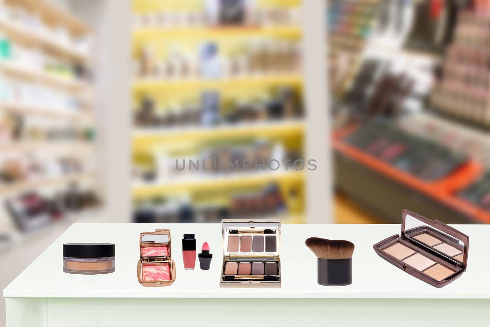 Colorful beauty and makeup products and tools on a bright table in front of blurred cosmetics store. Space for advertising.