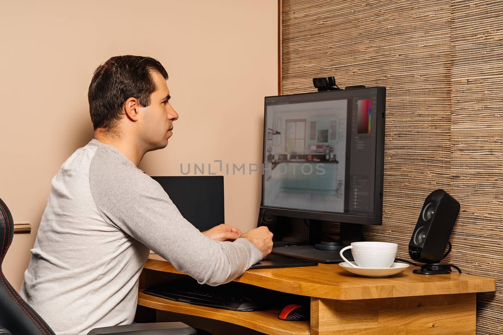 Middle age man working on graphic tablet and computer from comfort of his home during covid 19 or coronavirus pandemics, lockdown and quarantine