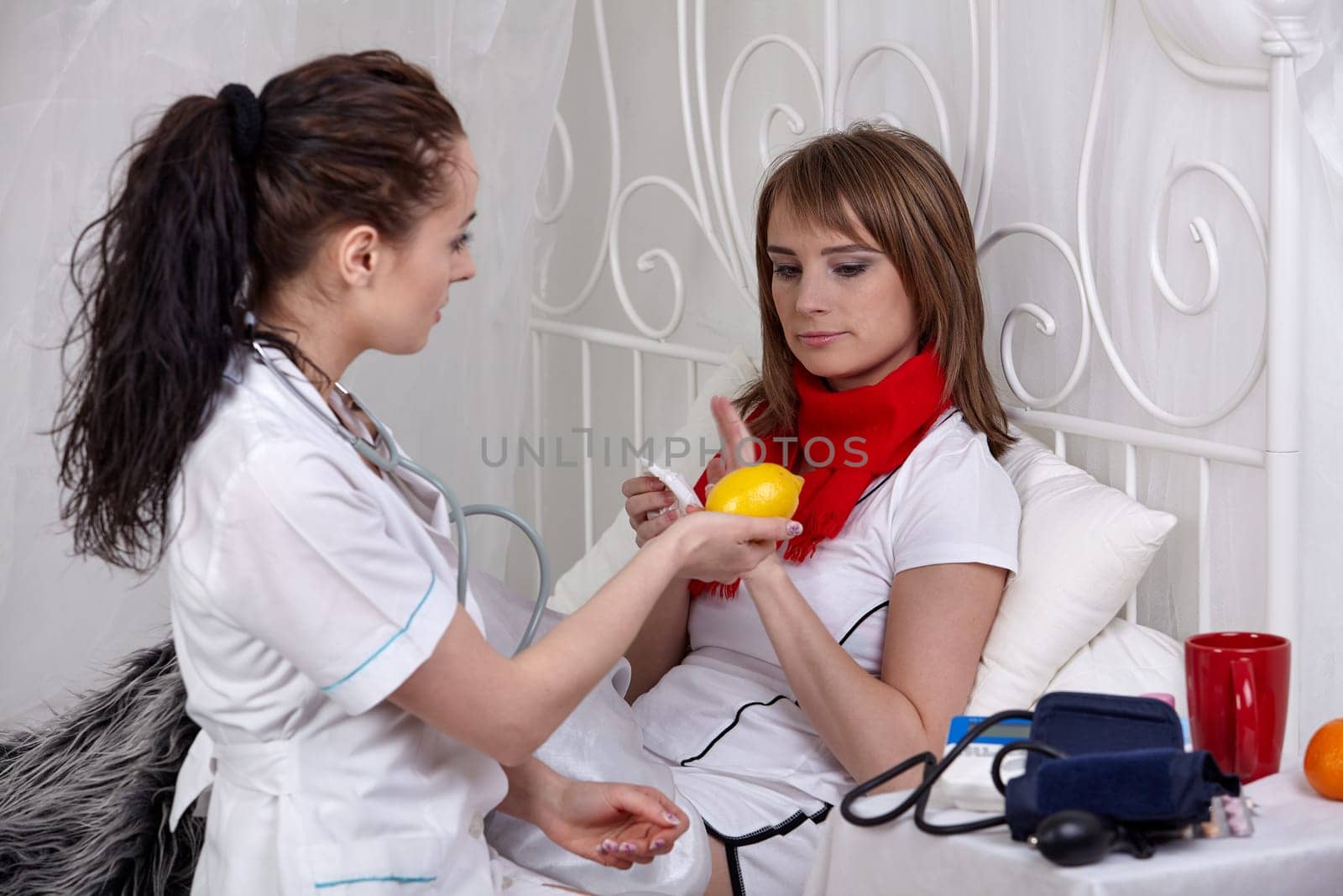 The doctor examines the ill girl lying in a bed. Selective focus.
