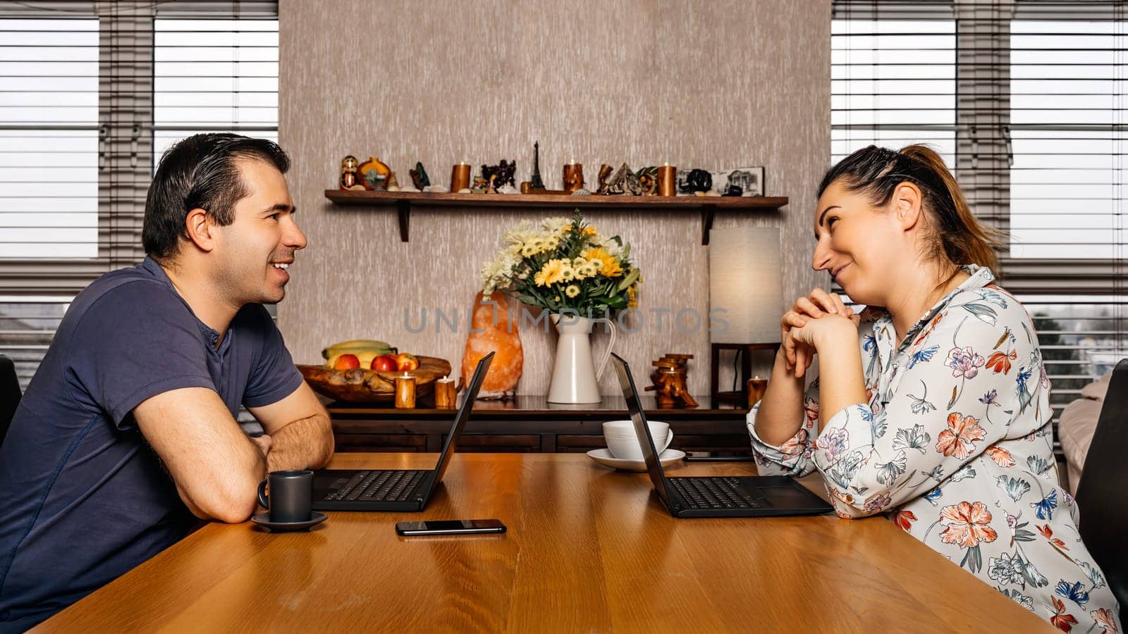 Men and woman, couple, talking and working on computers from comfort of their home during covid 19 or coronavirus pandemics, lockdown and quarantine