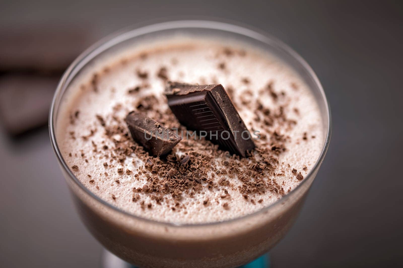 Chocolate curd dessert decorated with chocolate chips and pieces of chocolate
