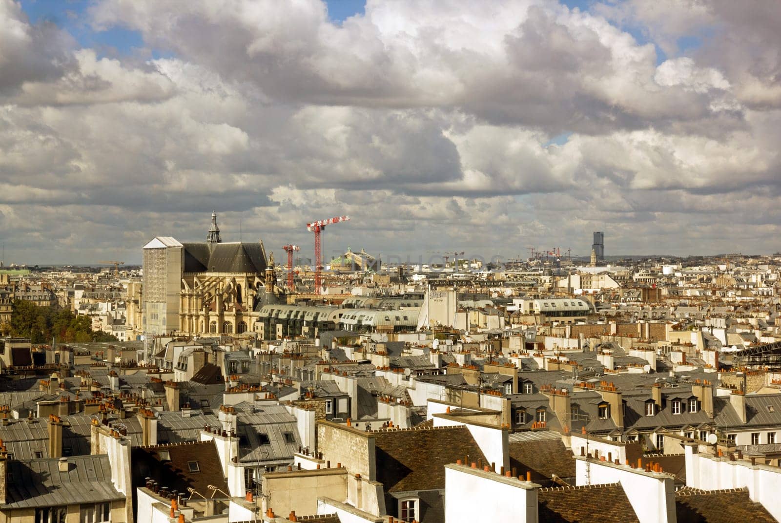 The roofs of Paris under a stormy sky. In the distance the Sacré Coeur (Paris France)