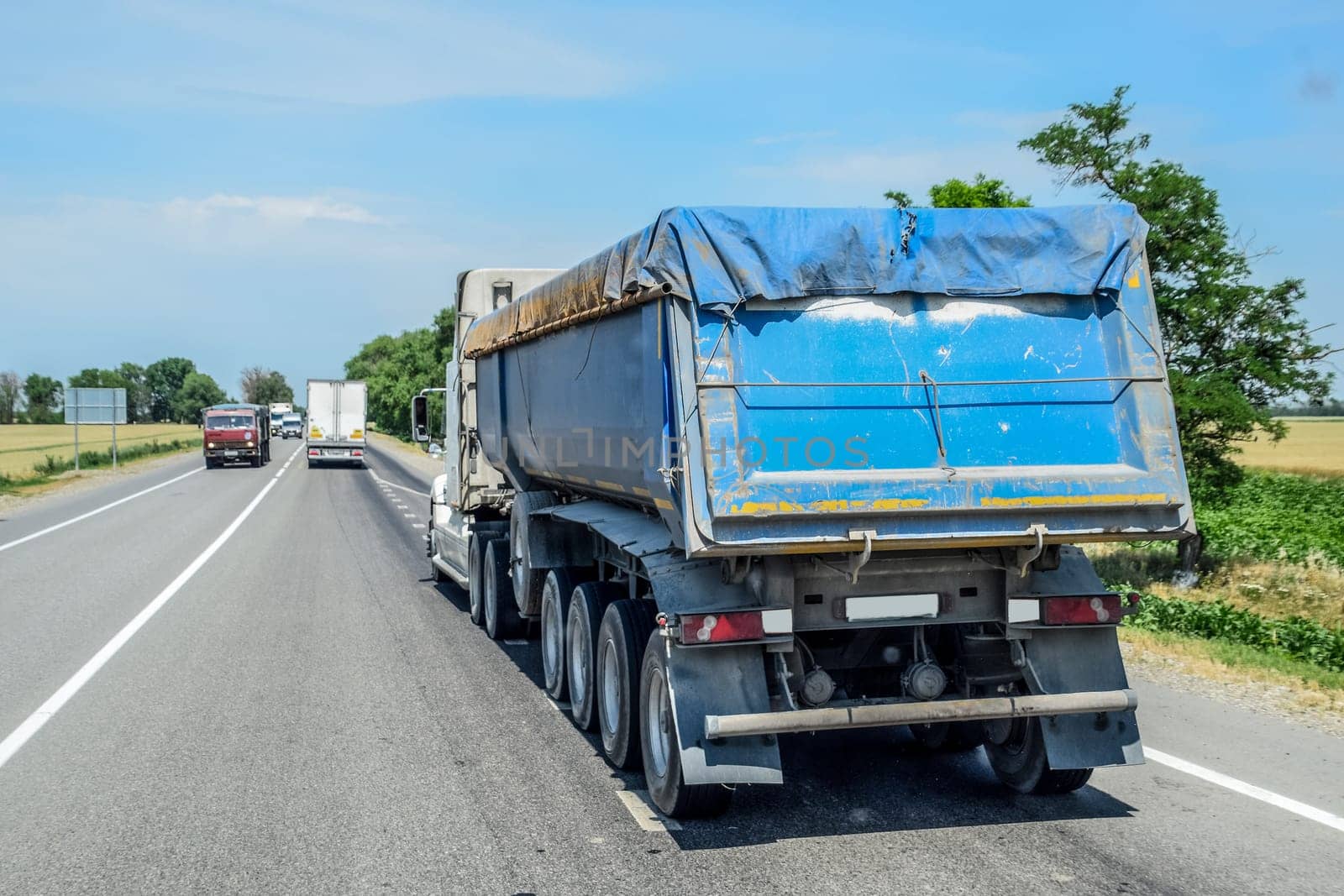 A truck of large capacity tonnar rides on the road.