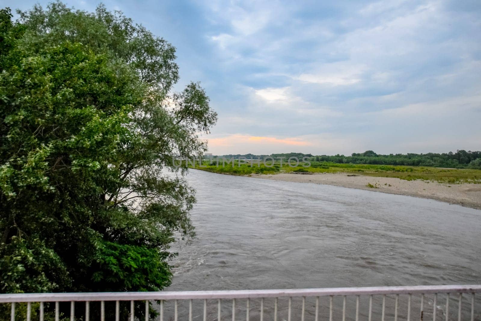 Passing over the bridge over the river. The landscape of the river, the surface and the trees of the river's waterplain.