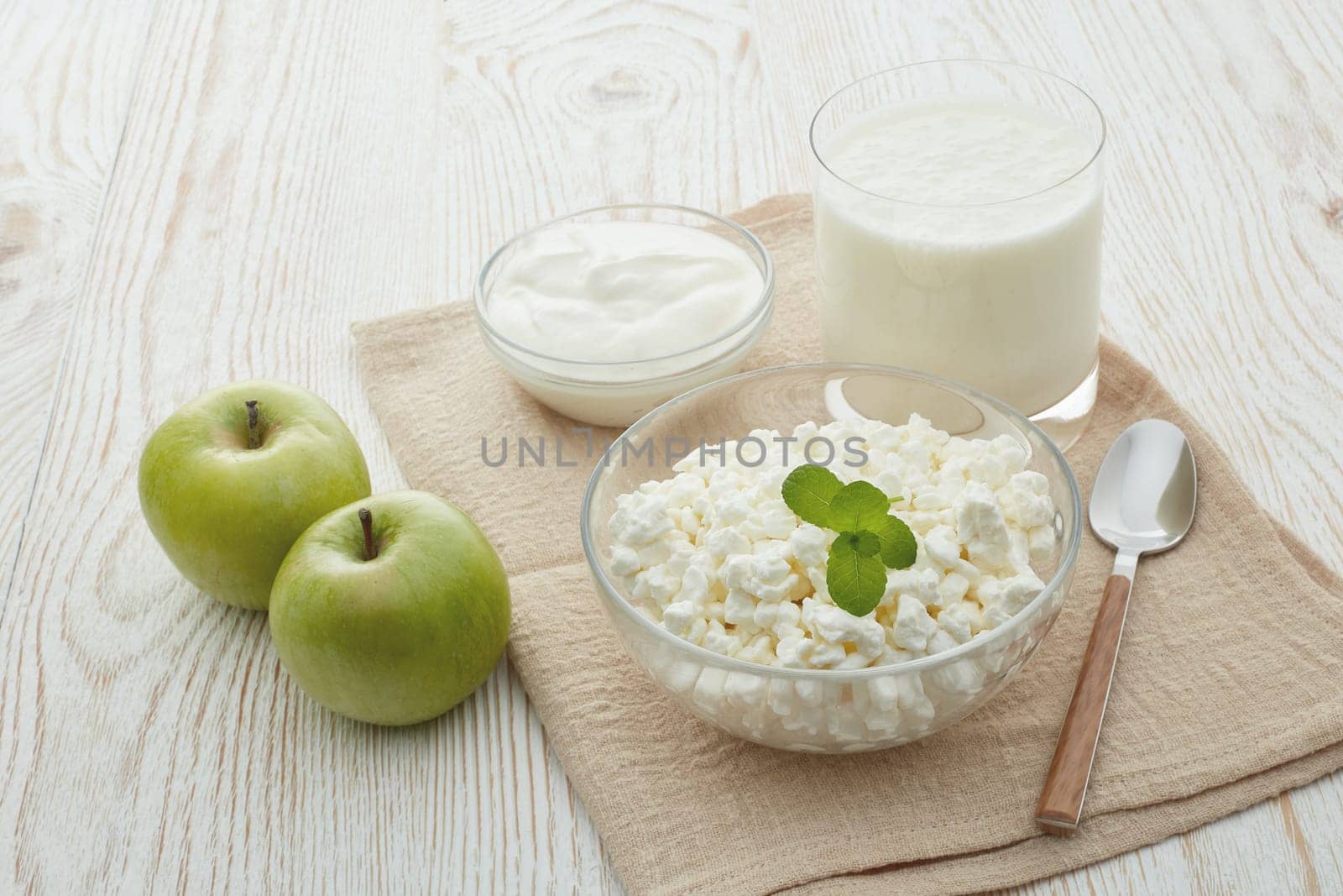 Still life with fresh village cottage cheese, sour cream, yogurt and two green apples. Healthy food. Dairy producst. Healthy meal. Dietary product.