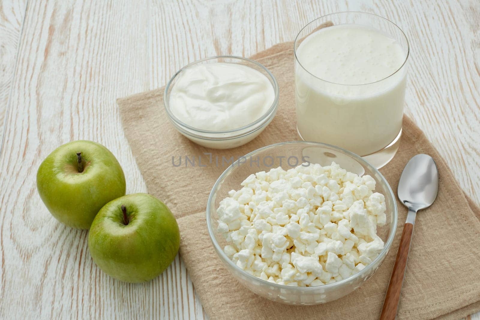 Still life with fresh village cottage cheese, sour cream, yogurt and two green apples. Healthy food. Dairy producst. Healthy meal. Dietary product.