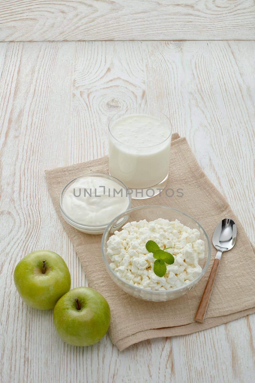 Still life with fresh village cottage cheese, sour cream, yogurt and two green apples. Healthy food. Dairy producst. Healthy meal. Dietary product.