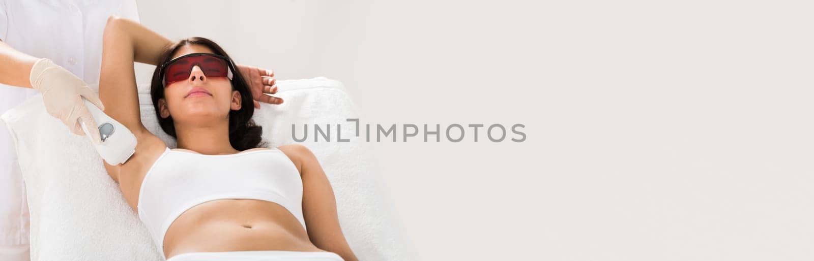 Woman Receiving Epilation Laser Treatment On Armpit At Beauty Clinic