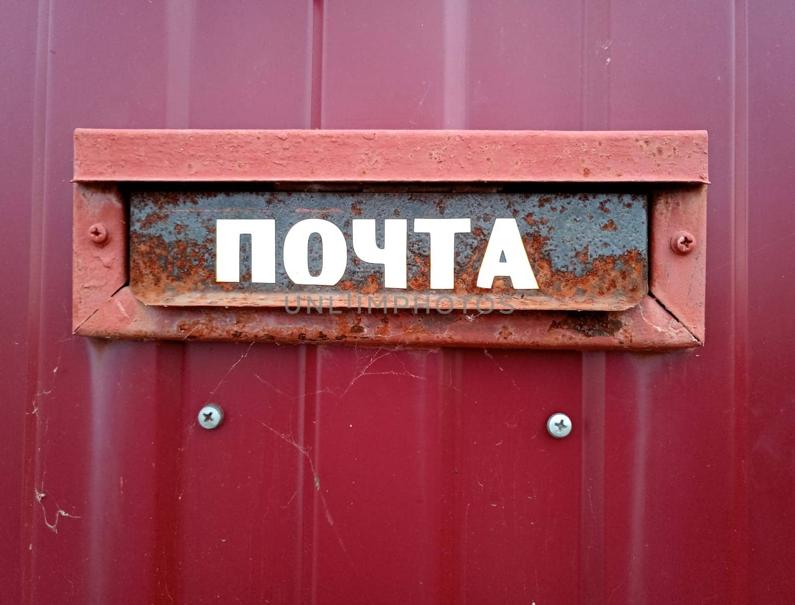 The inscription is mail. On a mailbox mounted in a fence.