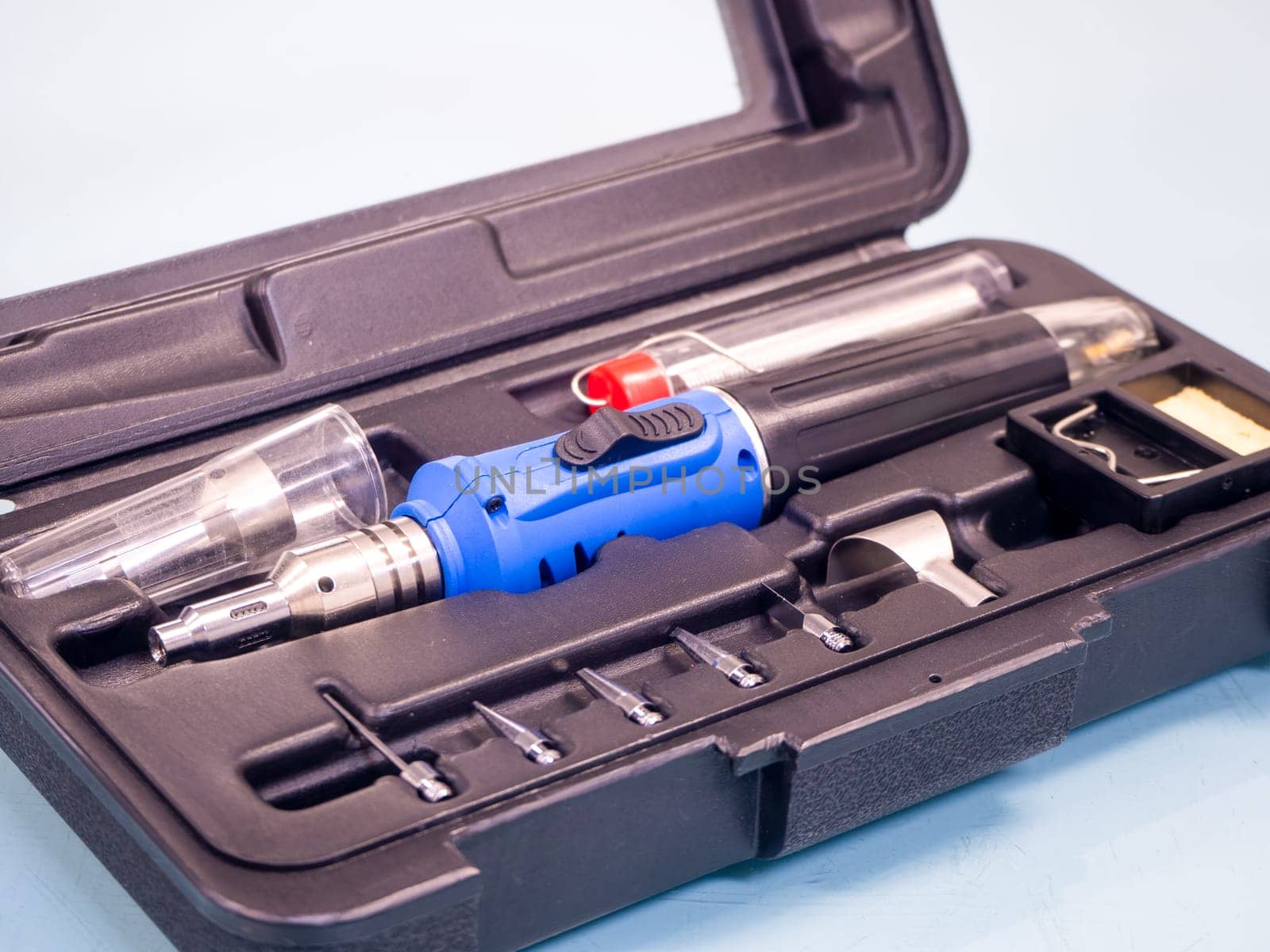 Gas soldering iron in black box isolated on white background.