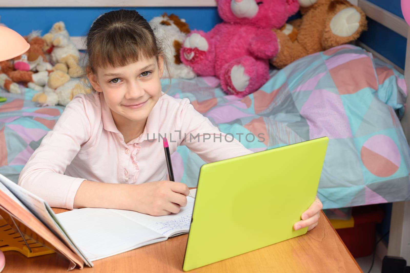 The girl is studying remotely at home and looked into the frame