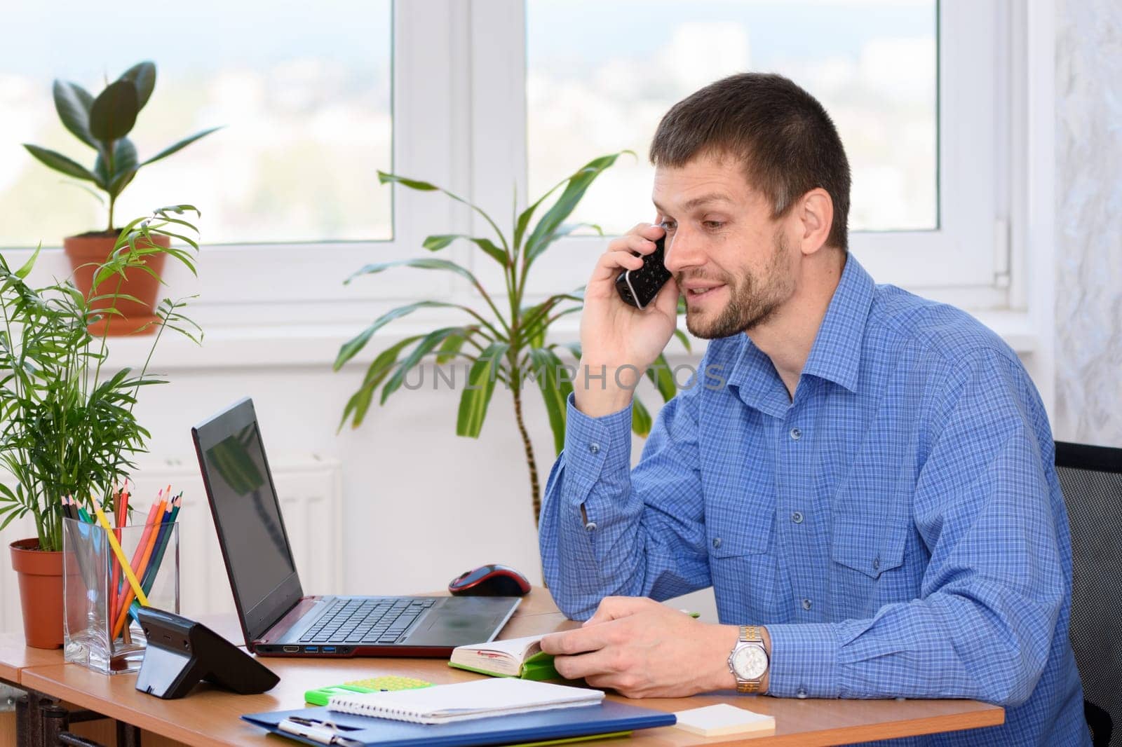 A man in the office talking on the phone