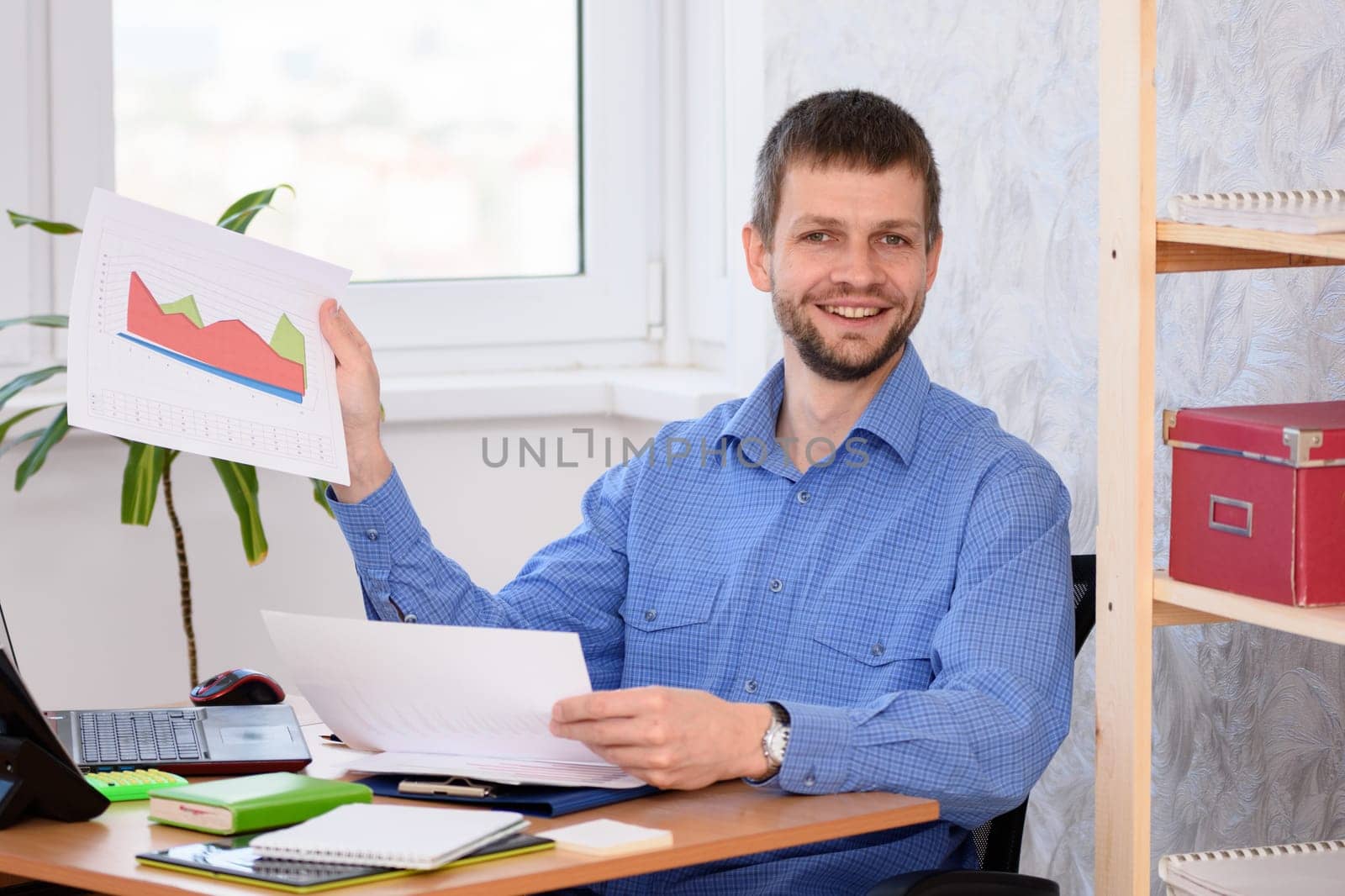 Office employee joyfully showing a document with charts