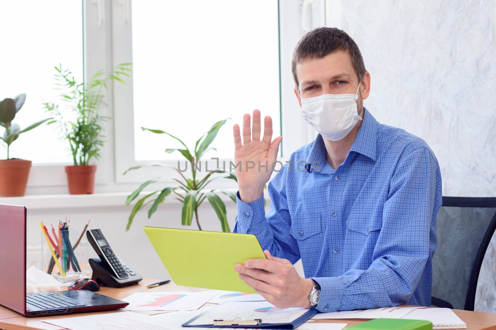 Portrait of an office worker in a medical mask working remotely