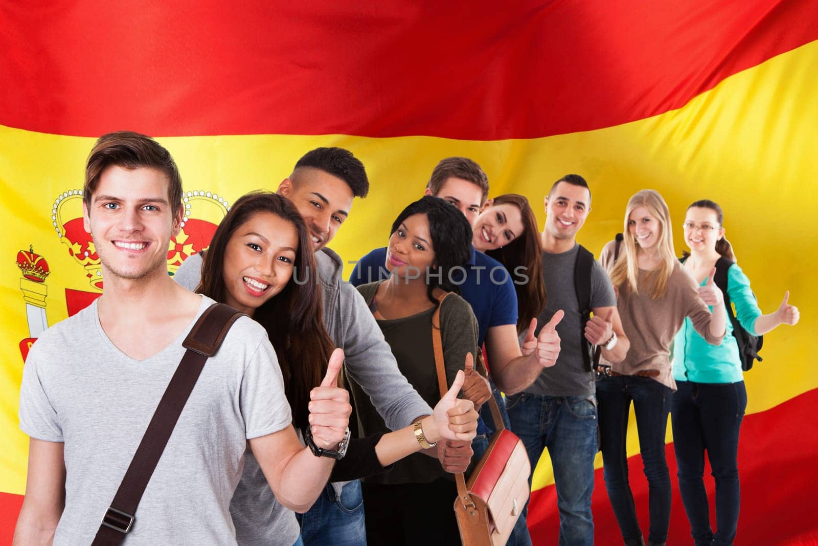 Portrait of college students gesturing thumbs up while standing in a line over white background