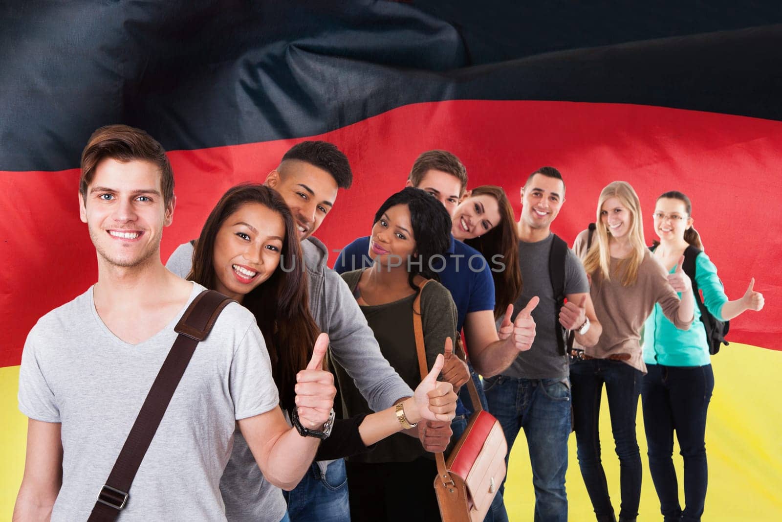 Portrait of college students gesturing thumbs up while standing in a line over white background