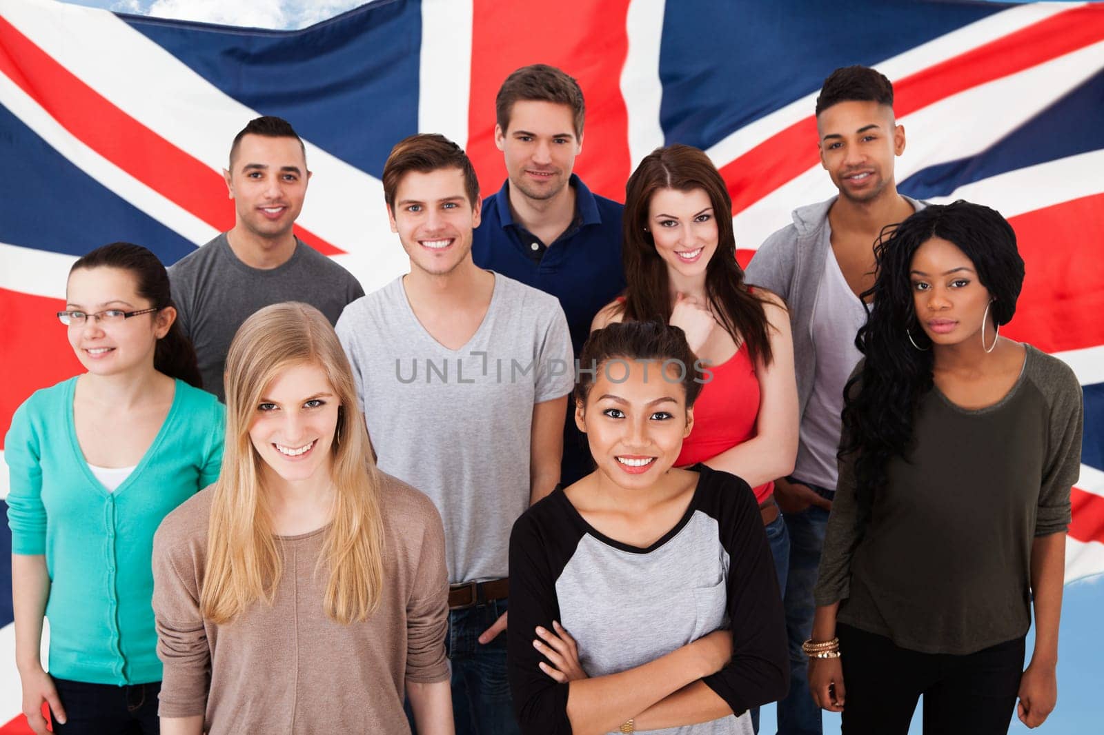 Group portrait of smiling multiethnic college students standing together in classroom