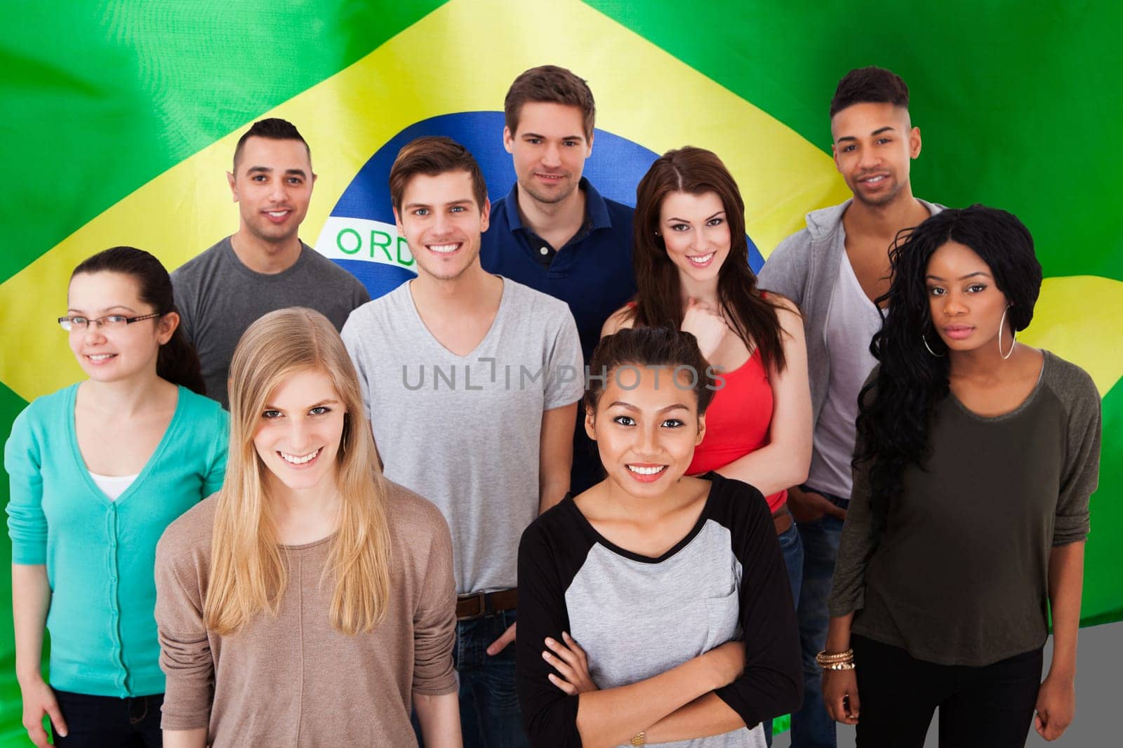 Group portrait of smiling multiethnic college students standing together in classroom