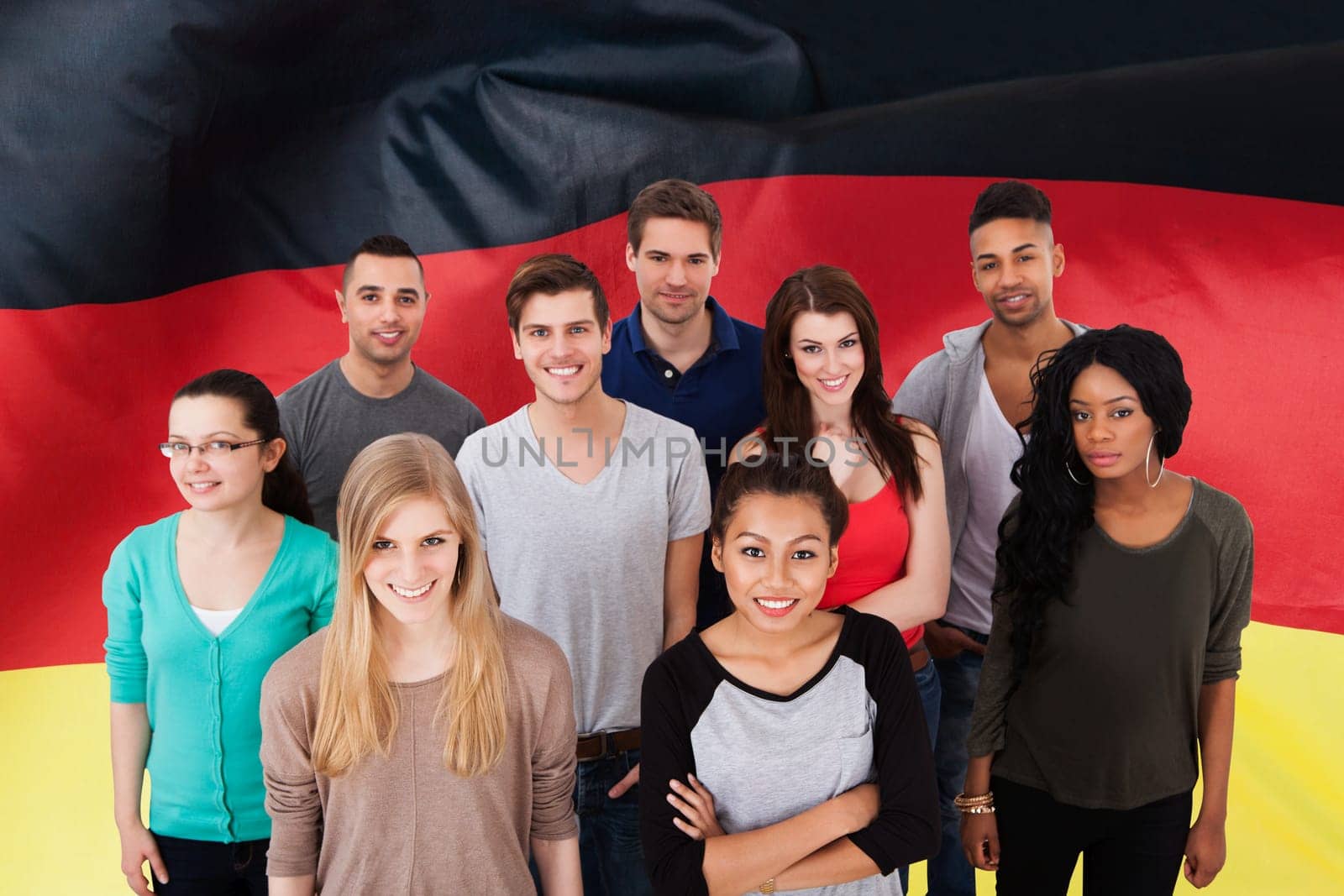 Group portrait of smiling multiethnic college students standing together in classroom