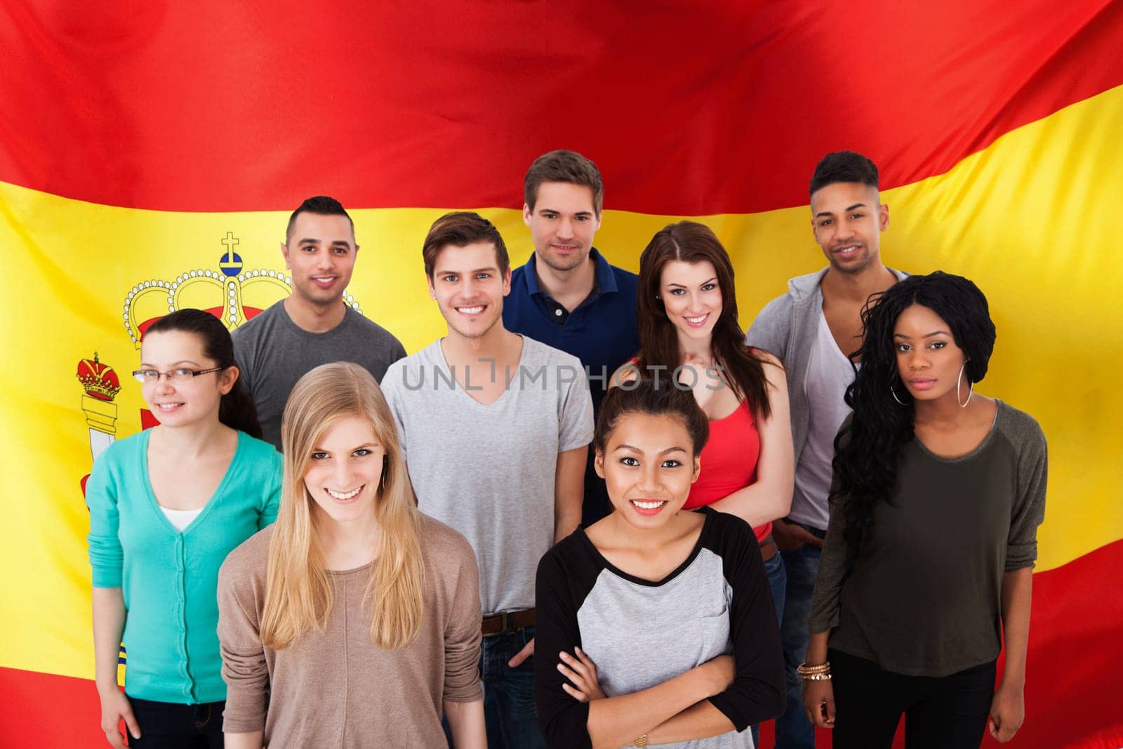 Group portrait of smiling multiethnic college students standing together in classroom