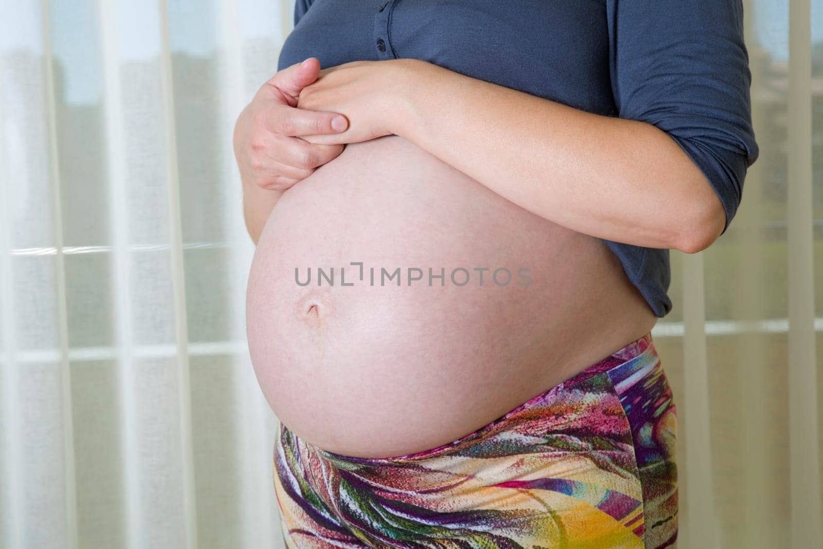 Closeup of pregnant woman at home