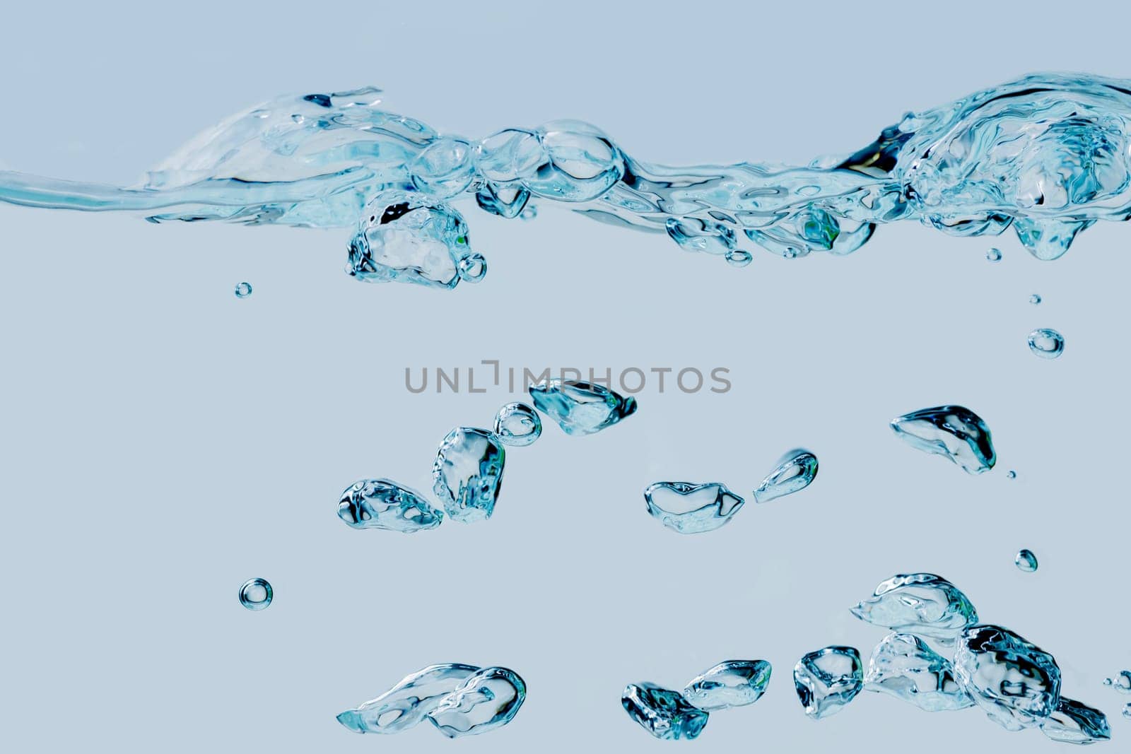 Full-format view of rising air bubbles in the medium of water against a light blue background.