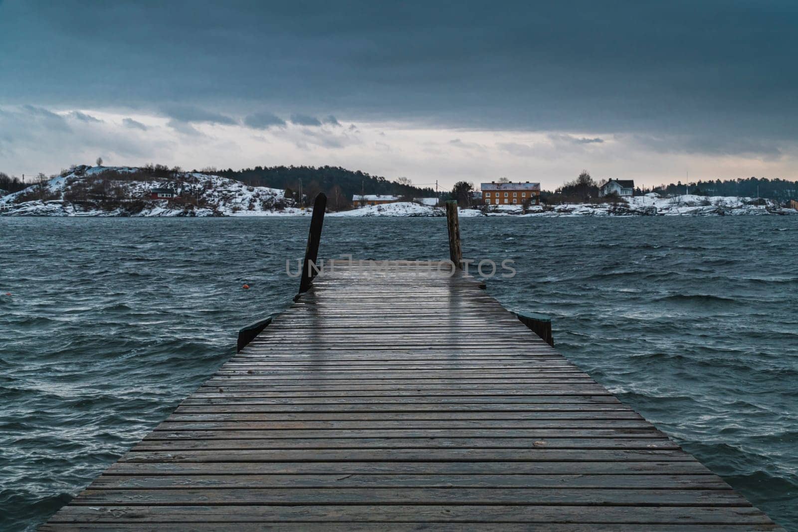 Old pier in Oslo goes to open sea in a cloudy day with wind